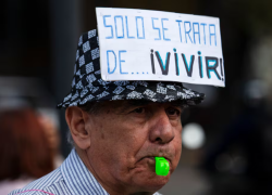 Jubilado con cartel con leyenda "solo se trata de vivir"